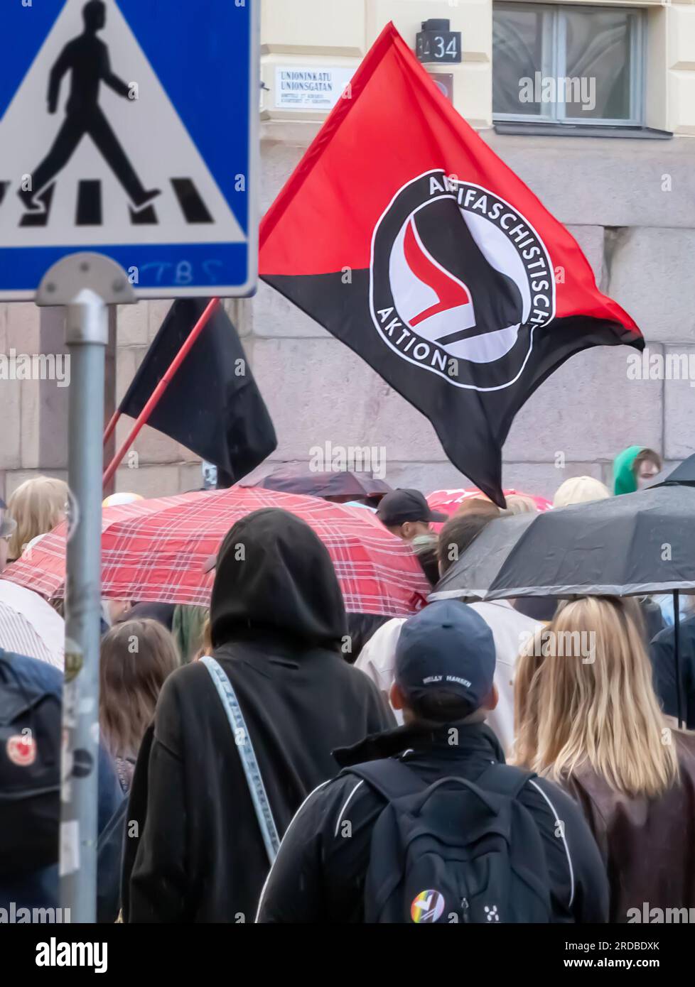 Partecipanti e una bandiera Antifa nella ‘tolleranza Zero! Razzisti fuori dalla marcia del governo, a Senaatintori. Foto Stock