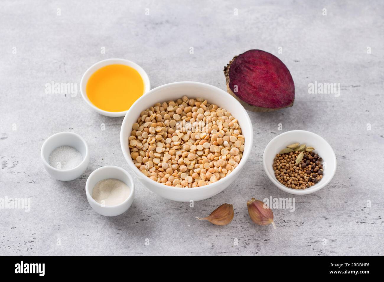 Ingredienti per deliziose salsicce di piselli vegani fatti in casa: Piselli secchi, barbabietola, sale, agar, olio vegetale, spezie, aglio su sfondo grigio. Foto Stock