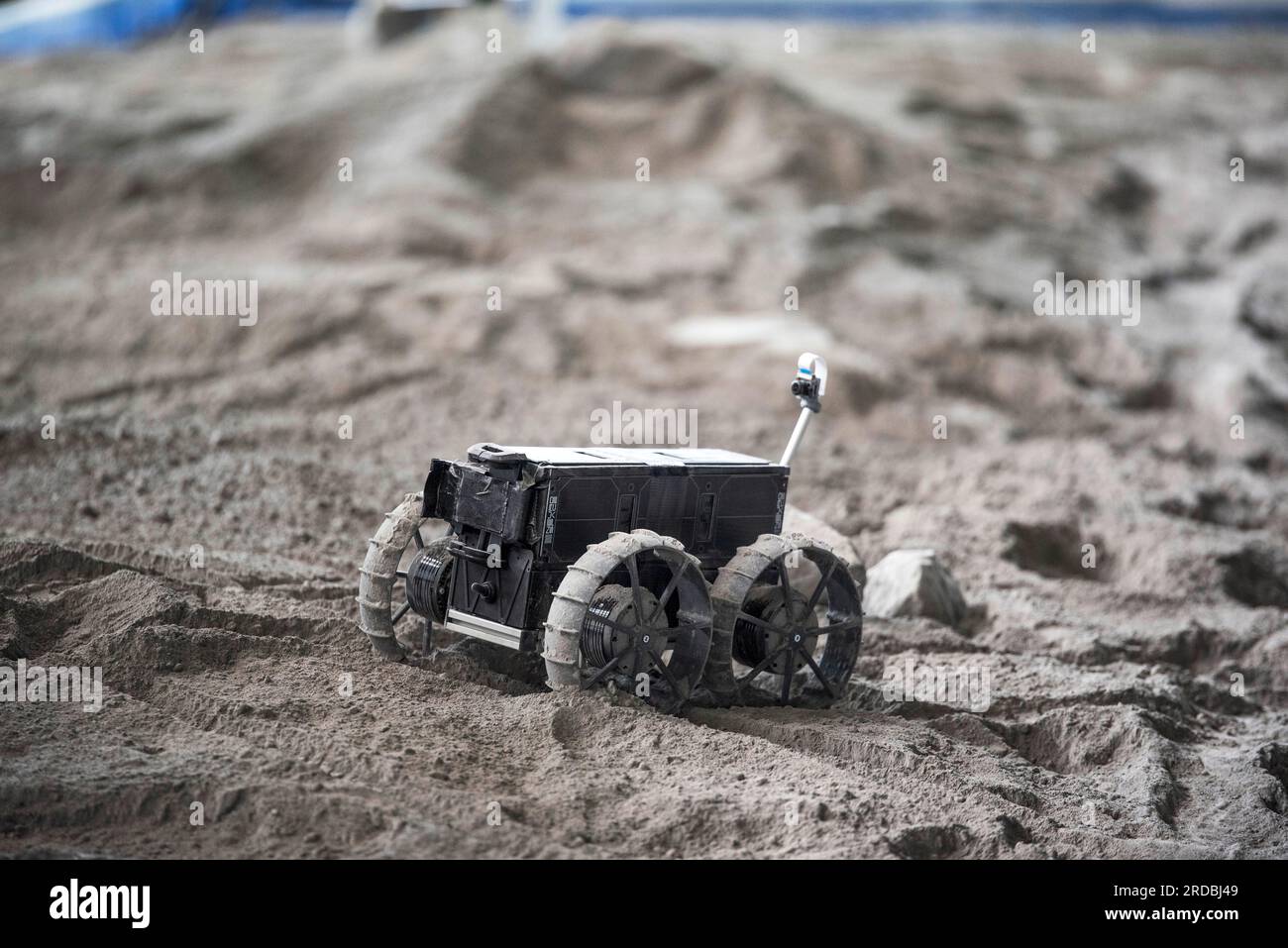 Rostock Laage, Germania. 20 luglio 2023. Un rover lunare guida su un campo di prova nel terminal dell'aeroporto di Rostock-Laage. Il letto lunare costruito artificialmente nel terminal dell'aeroporto è lungo circa 18 metri, largo cinque metri e pieno di "polvere lunare" sulla superficie. In occasione della giornata internazionale della luna che commemora il primo atterraggio con equipaggio il 20 luglio 1969, i piccoli rover di prova stanno ancora arando attraverso un paesaggio lunare creato artificialmente all'aeroporto di Rostock-Laage. Crediti: Frank Hormann/dpa/Alamy Live News Foto Stock Rostock Laage, Germania. 20 luglio 2023. Un rover lunare guida su un campo di prova nel terminal dell'aeroporto di Rostock-Laage. Il letto lunare costruito artificialmente nel terminal dell'aeroporto è lungo circa 18 metri, largo cinque metri e pieno di "polvere lunare" sulla superficie. In occasione della giornata internazionale della luna che commemora il primo atterraggio con equipaggio il 20 luglio 1969, i piccoli rover di prova stanno ancora arando attraverso un paesaggio lunare creato artificialmente all'aeroporto di Rostock-Laage. Crediti: Frank Hormann/dpa/Alamy Live News Foto Stock