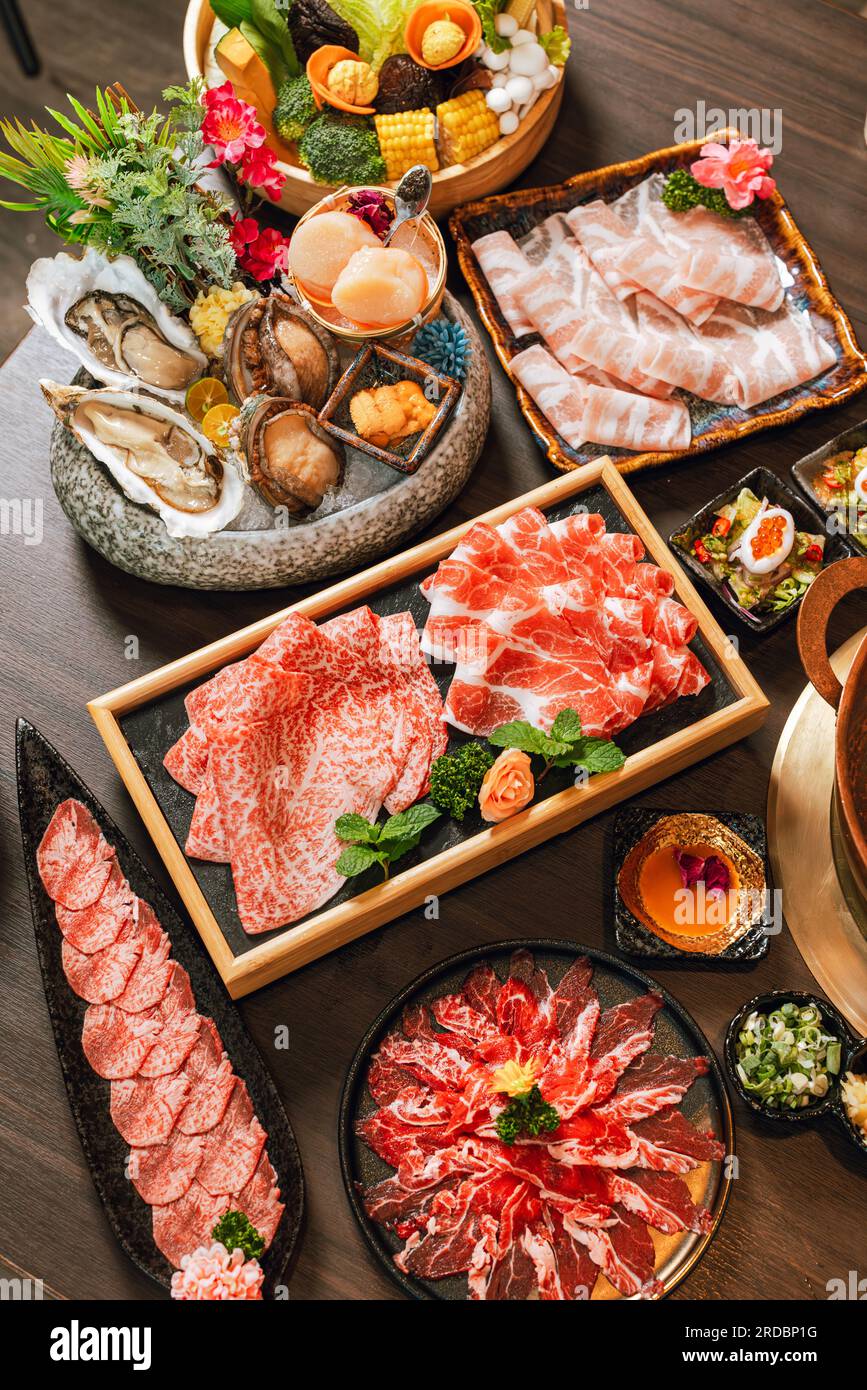 Piatti di cucina a base di pesce e carne a fette di manzo per pentole calde. fette di maiale, capesante, conchiglie, ostriche, caviale e altre prelibatezze di pesce. Foto Stock