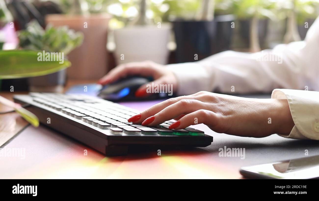 Mani sulla tastiera in primo piano, lavoro in ufficio in remoto da casa. Donna bianca che digita sulla tastiera. Apprendimento a distanza, formazione online e lavoro sul co Foto Stock