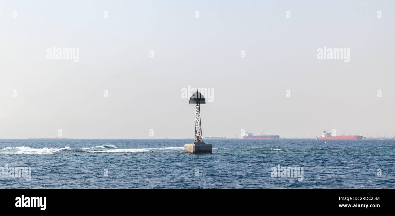 Torre faro montata al confine di un fairway, struttura incorniciata con triangolo superiore si erge nell'acqua del Golfo Persico, Arabia Saudita Foto Stock