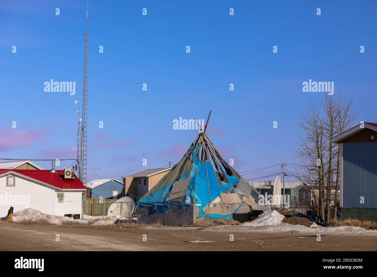 Le piastre satellitari che forniscono un raro punto di contatto con il mondo esterno fiancheggiano un tradizionale teepee nella città indigena di Fort Severn su Hudso Foto Stock