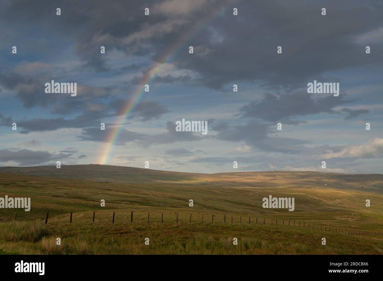 Rainbow sopra i North Pennines. Campi illuminati da luce transitoria. Foto Stock