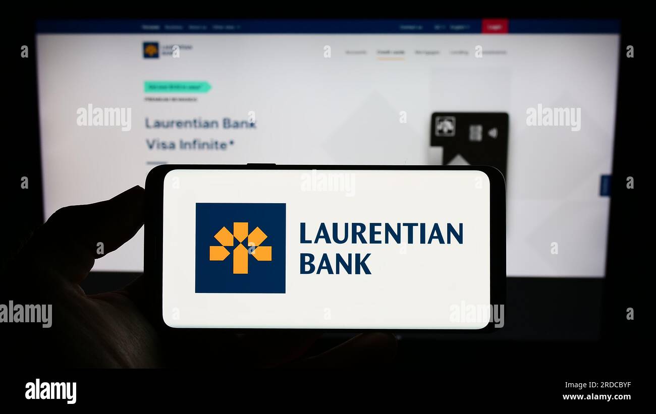 Persona in possesso di un cellulare con il logo della società finanziaria Laurentian Bank of Canada (LBC) sullo schermo davanti alla pagina Web. Concentrarsi sul display del telefono. Foto Stock