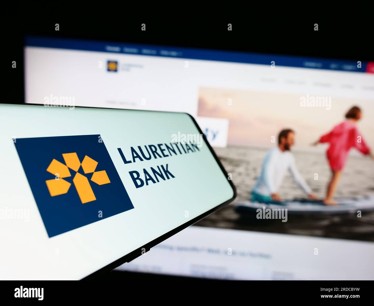 Cellulare con logo della società finanziaria Laurentian Bank of Canada (LBC) sullo schermo davanti al sito Web. Mettere a fuoco il display centrale sinistro del telefono. Foto Stock