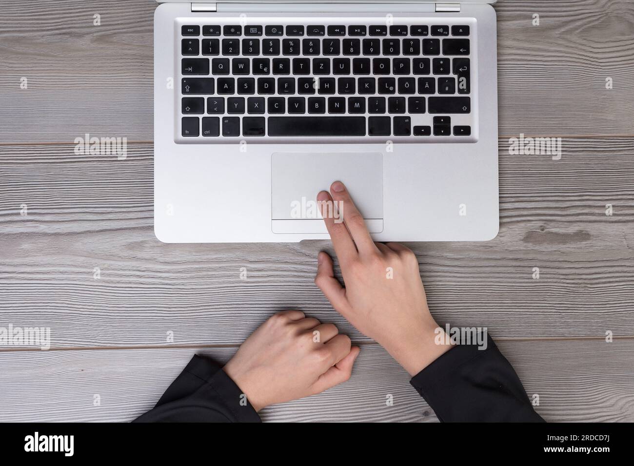 Il gesto del touchpad di una donna catturato dall'alto. Simboleggia la facilità d'uso della tecnologia e il suo impatto sulla produttività umana Foto Stock