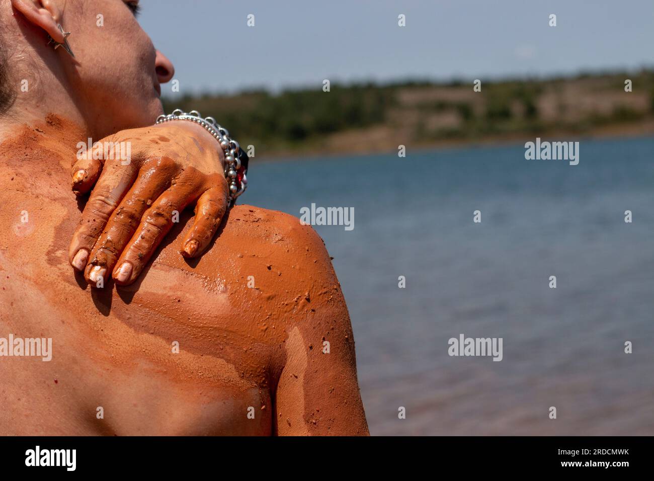 Bagno di fango riabilitante, esfoliante e curativo sulla pelle di una donna, in un lago a Castilla y León in Spagna. di argilla Foto Stock