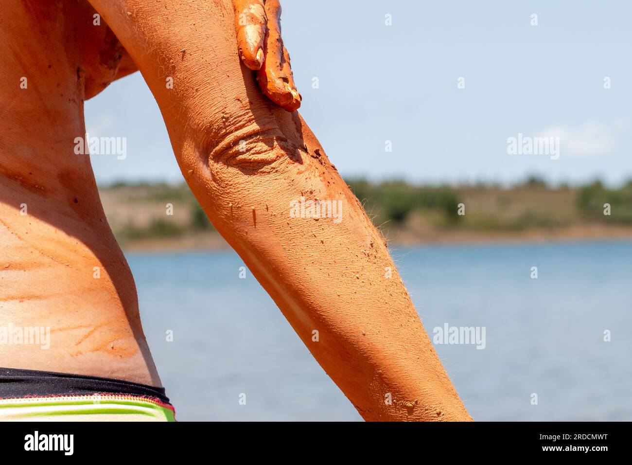 Bagno di fango riabilitante, esfoliante e curativo sulla pelle di una donna, in un lago a Castilla y León in Spagna. di argilla Foto Stock