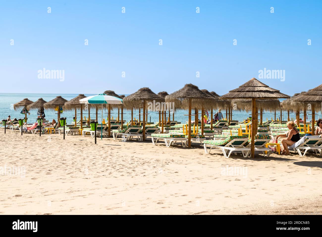 I turisti sulla spiaggia nella famosa località mediterranea di la Carihuela con la sua vita balneare estiva. Foto Stock