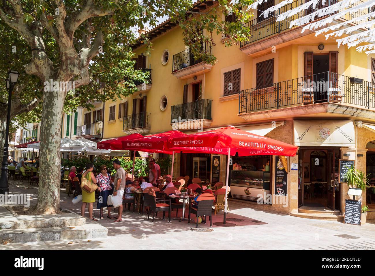 La gente si gode la terrazza all'angolo della strada nel centro dell'accogliente Arta Foto Stock