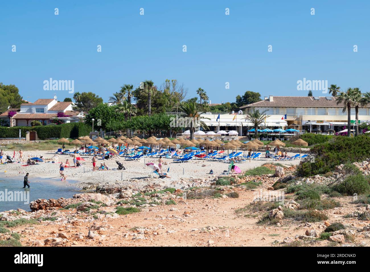 I turisti si godono l'acqua di mare nella località di Son Xoriguer vicino a Cala en Bosch, sull'isola spagnola di Minorca. Foto Stock
