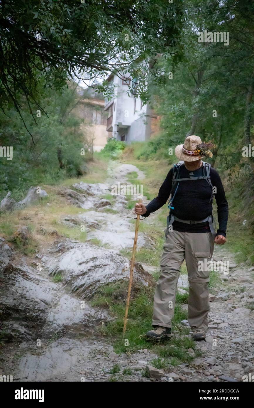 Un uomo solitario lascia El Acebo de San Miguel lungo un sentiero roccioso lungo il Camino fino a Santiago de Compostela, Spagna Foto Stock