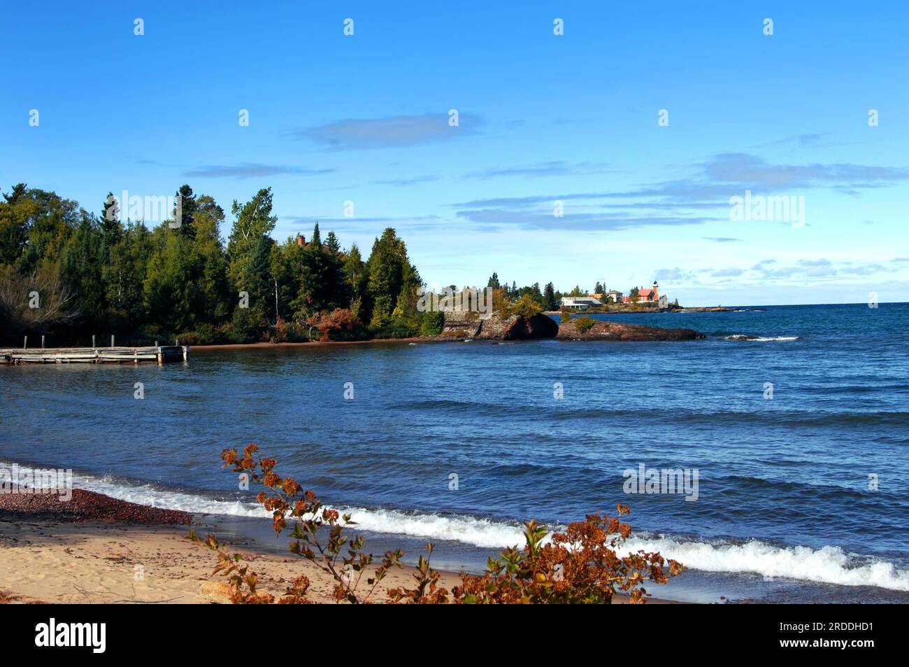 Immagine delle facciate dei pontili in legno; rustico e resistente alle intemperie sul lago Superior, Michigan. Lo sfondo mostra il faro di Eagle Harbor e la penisola di Keweenaw. Foto Stock