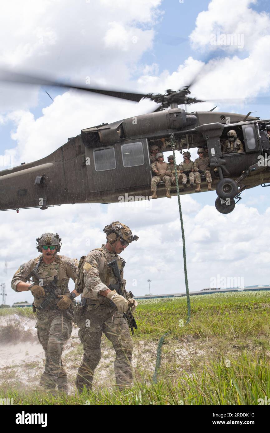 Durante un'esercitazione congiunta, membri militari di sette paesi (Guyana, Stati Uniti, Repubblica Dominicana, Messico, Belize, Saint Lucia, Trinidad, E Tobago), cordata veloce da un elicottero UH60 Blackhawk per simulare un metodo sicuro ed efficace di inserimento e rimozione del personale da e verso luoghi specifici dove sarebbe difficile o impossibile atterrare un aereo in sicurezza durante TRADEWINDS23 presso Air base London, Guyana, il 17 luglio 2023. Foto Stock