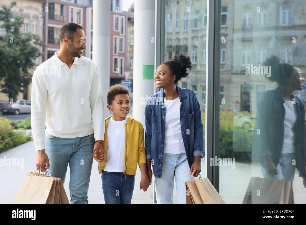Shopping per famiglie. Genitori e figli felici con acquisti vicino al centro commerciale all'aperto Foto Stock