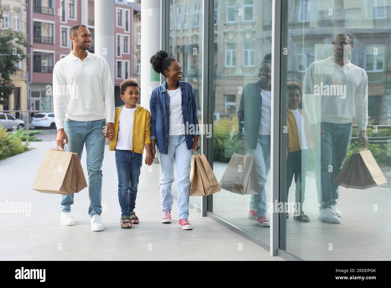 Shopping per famiglie. Genitori e figli felici con acquisti vicino al centro commerciale all'aperto Foto Stock
