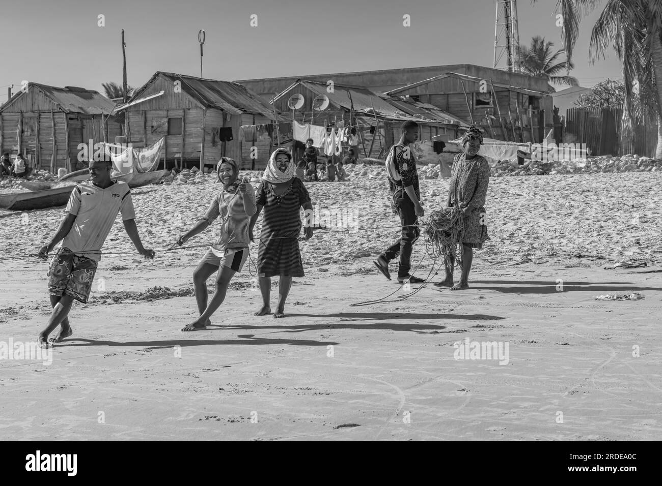 Morondava, Madagascar - 31 maggio 2023: La gente tira una corda per pescare sulla costa da Morondava, bianco e nero Foto Stock