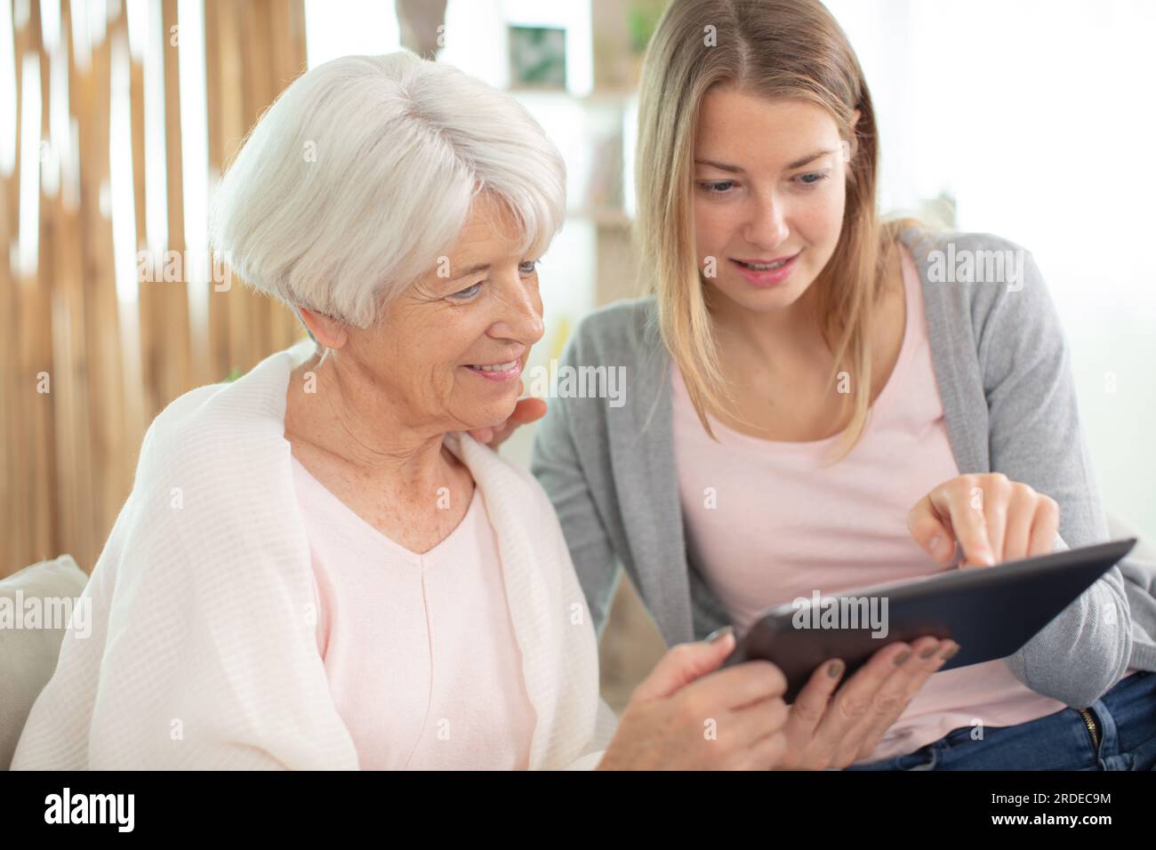 madre matura e sua figlia adulta utilizzando un tablet digitale Foto Stock