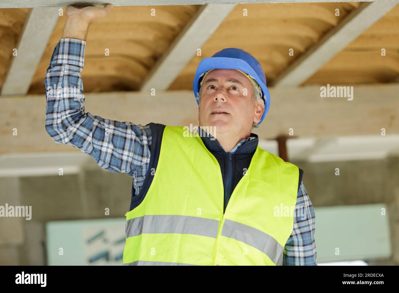 uomo che lavora alla costruzione di case a soffitto Foto Stock