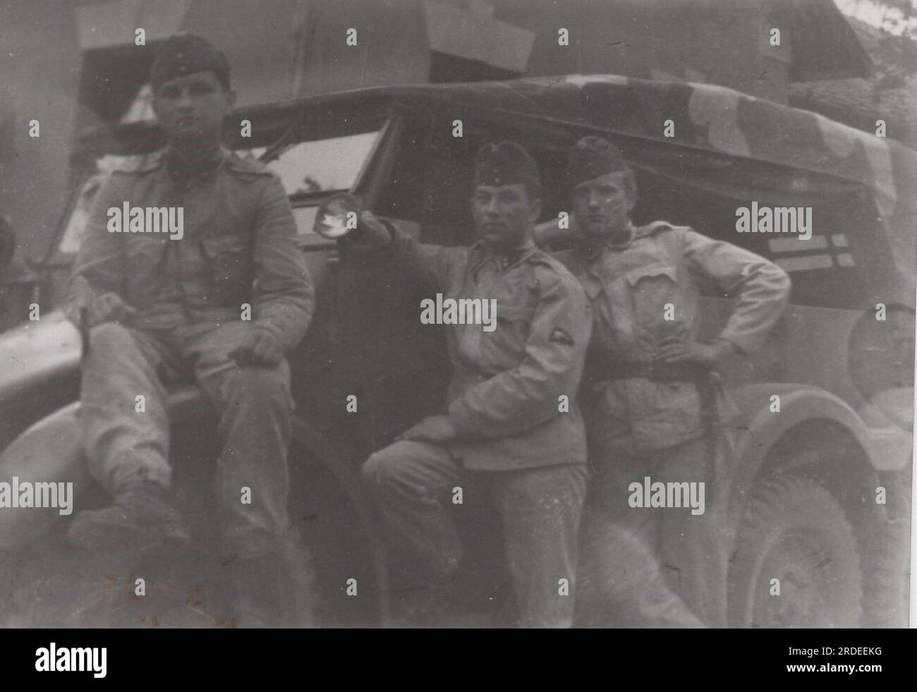 i giovani soldati fingono in uniforme con un enorme veicolo militare negli anni '1950 o '1960 Questa e' un'auto fuori strada del comandante e' davvero impressionante. Foto Stock