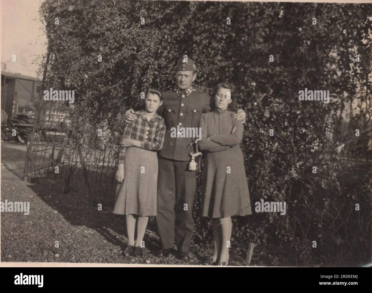 foto di famiglia vintage. Moglie e figlia stanno con il padre soldato che indossa la sua uniforme con la spada Foto Stock