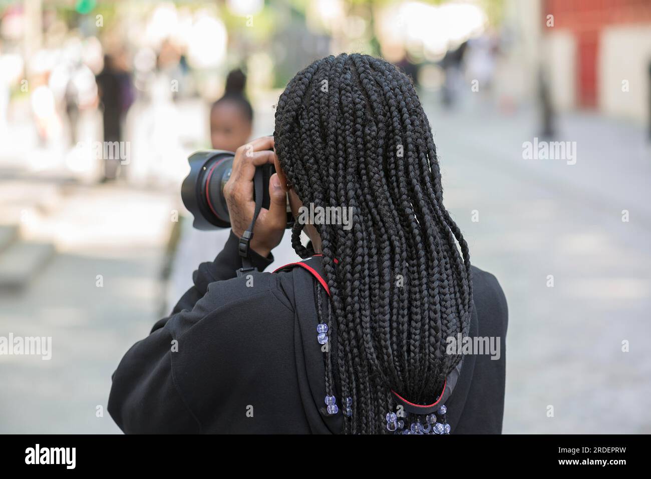 Giovane ragazza con dreadlocks neri che scatta una foto, Parigi, Francia Foto Stock