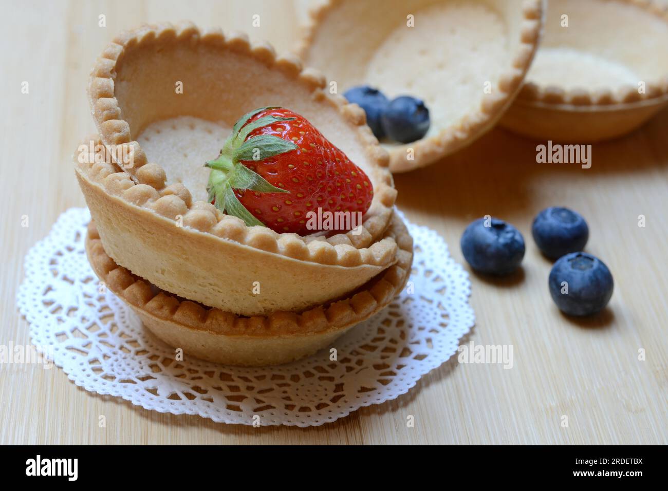 Tartelette, base di tartaruga prefabbricata con fragole e mirtilli Foto Stock