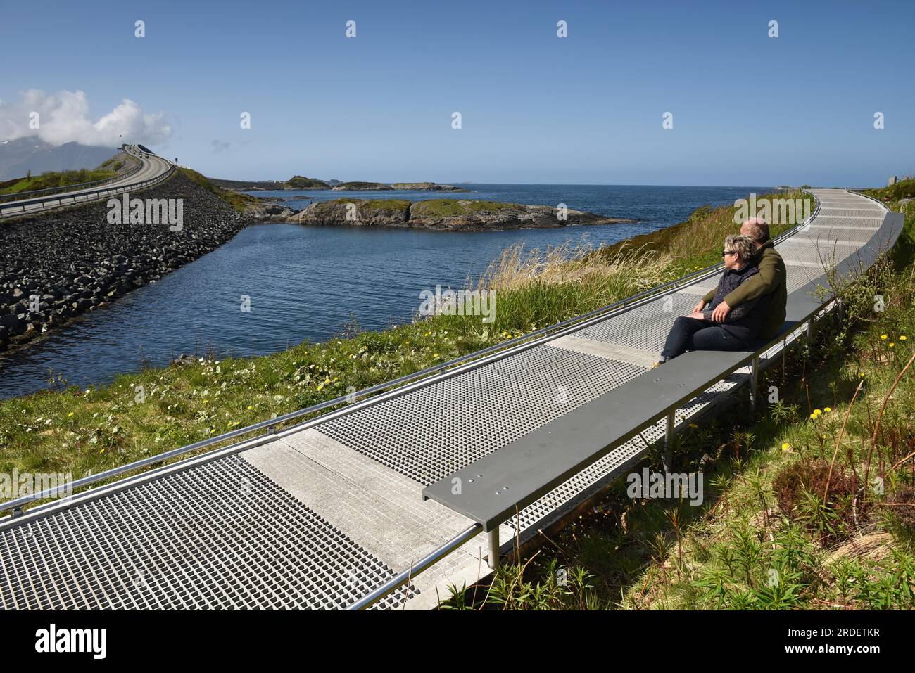 Coppia seduta su una panchina sulla Atlantic Road in Norvegia Foto Stock