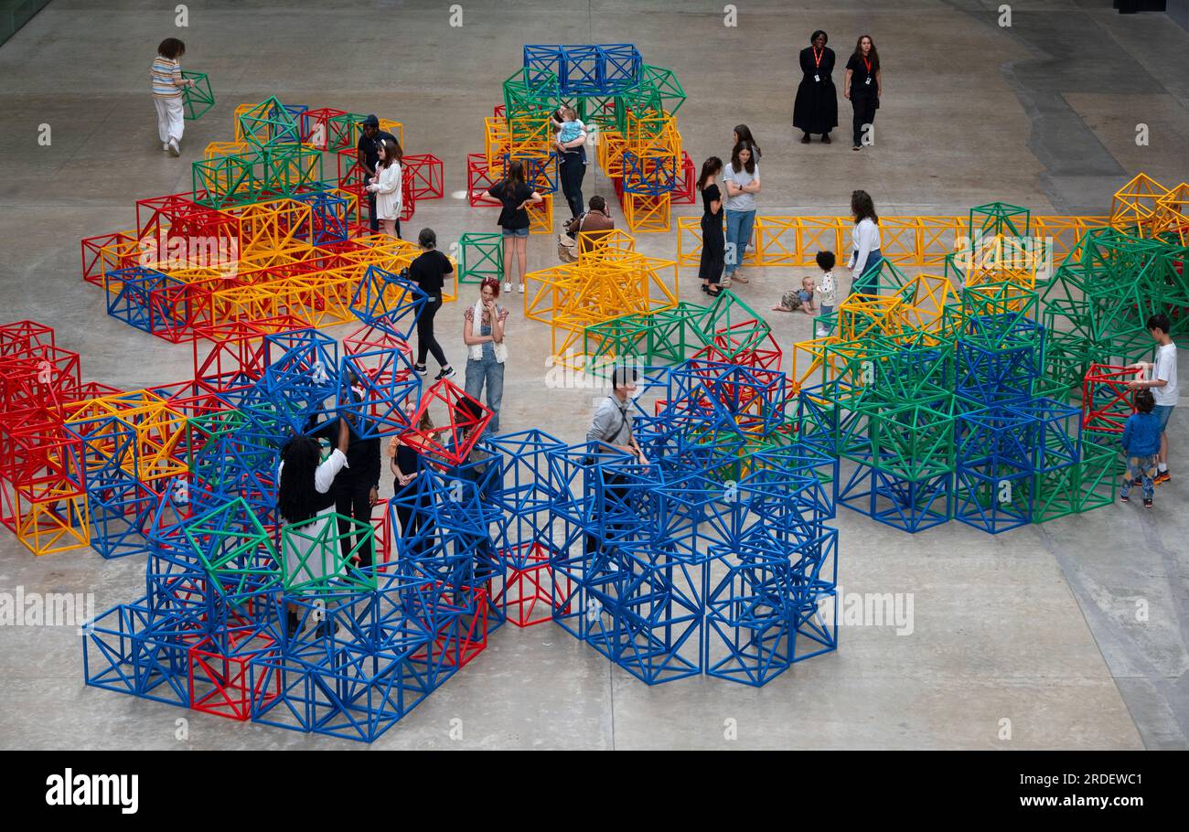 Tate Modern, Londra, Regno Unito. 21 luglio 2023. (L'immagine PUÒ essere utilizzata SOLO per illustrare la mostra specificata alla Tate Modern). La colorata scultura interattiva di Rasheed Araeen Zero to Infinity arriva alla Tate Modern turbine Hall per l'estate come parte del gioco UNIQLO Tate Play, attività gratuite per tutti i visitatori dal 22 luglio al 28 agosto. Ogni mattina vengono disposti in modo ordinato cubi di costruzione di lattice dai colori vivaci. Le persone possono smantellare la struttura simmetrica e impilare, inclinare e bilanciare i cubi in nuove forme per creare opere d'arte in continua evoluzione. (Famiglie fornite da Tate). Crediti: Malcolm Park/Alamy Live News Foto Stock