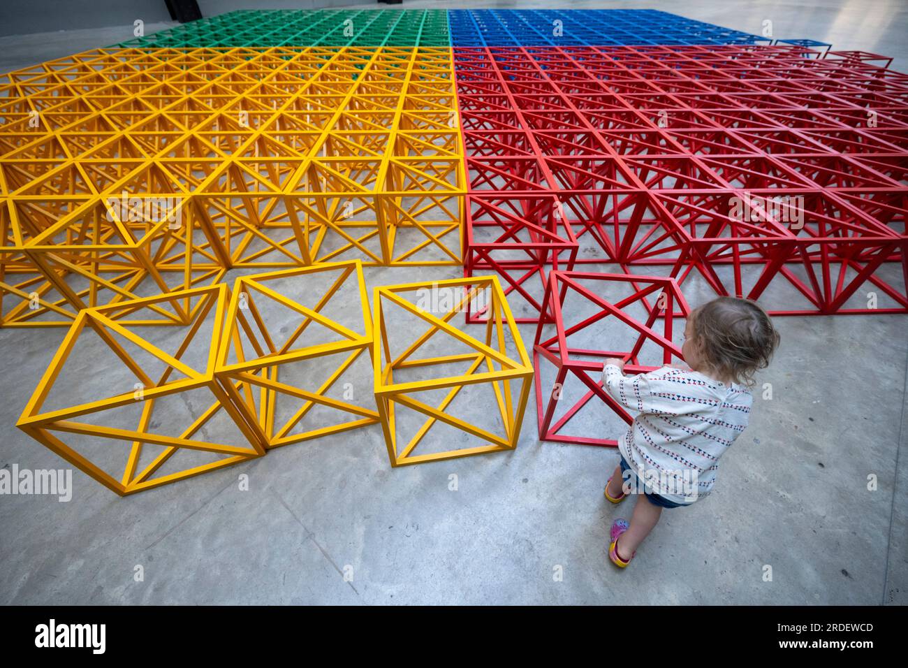 Tate Modern, Londra, Regno Unito. 21 luglio 2023. (L'immagine PUÒ essere utilizzata SOLO per illustrare la mostra specificata alla Tate Modern). La colorata scultura interattiva di Rasheed Araeen Zero to Infinity arriva alla Tate Modern turbine Hall per l'estate come parte del gioco UNIQLO Tate Play, attività gratuite per tutti i visitatori dal 22 luglio al 28 agosto. Ogni mattina vengono disposti in modo ordinato cubi di costruzione di lattice dai colori vivaci. Le persone possono smantellare la struttura simmetrica e impilare, inclinare e bilanciare i cubi in nuove forme per creare opere d'arte in continua evoluzione. (Famiglie fornite da Tate). Crediti: Malcolm Park/Alamy Live News Foto Stock