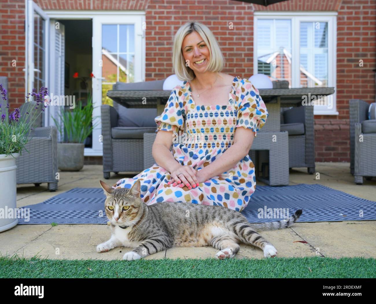 Dave il gatto, raffigurato nella sua nuova casa con il manager delle operazioni dei media della Football Association, Anna Bush. L'improbabile mascotte inglese della Coppa del mondo guarderà ora le Lionesse dalla sua eterna casa mentre Dave the Cat si stabilisce nel suo nuovo ambiente. Anche se il calcio potrebbe non essere tornato a casa dal Qatar, il gatto randagio Dave lo fece dopo che il felino amichevole divenne un favorito fisso della squadra mentre vagava liberamente per la base di allenamento inglese di al Wakrah. Nonostante la loro uscita nei quarti di finale per mano della Francia, a Dave fu ancora data la possibilità di recarsi nel Regno Unito e alla fine fu reintegrato dal Football A. Foto Stock