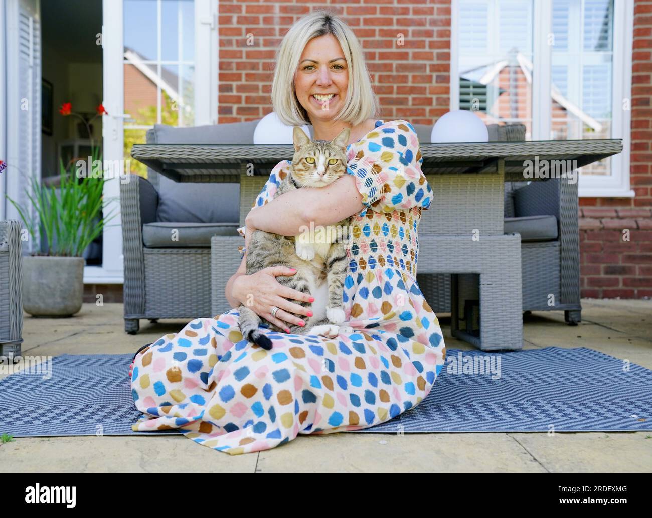 Dave il gatto, raffigurato nella sua nuova casa con il manager delle operazioni dei media della Football Association, Anna Bush. L'improbabile mascotte inglese della Coppa del mondo guarderà ora le Lionesse dalla sua eterna casa mentre Dave the Cat si stabilisce nel suo nuovo ambiente. Anche se il calcio potrebbe non essere tornato a casa dal Qatar, il gatto randagio Dave lo fece dopo che il felino amichevole divenne un favorito fisso della squadra mentre vagava liberamente per la base di allenamento inglese di al Wakrah. Nonostante la loro uscita nei quarti di finale per mano della Francia, a Dave fu ancora data la possibilità di recarsi nel Regno Unito e alla fine fu reintegrato dal Football A. Foto Stock