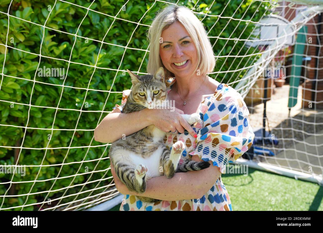 Dave il gatto, raffigurato nella sua nuova casa con il manager delle operazioni dei media della Football Association, Anna Bush. L'improbabile mascotte inglese della Coppa del mondo guarderà ora le Lionesse dalla sua eterna casa mentre Dave the Cat si stabilisce nel suo nuovo ambiente. Anche se il calcio potrebbe non essere tornato a casa dal Qatar, il gatto randagio Dave lo fece dopo che il felino amichevole divenne un favorito fisso della squadra mentre vagava liberamente per la base di allenamento inglese di al Wakrah. Nonostante la loro uscita nei quarti di finale per mano della Francia, a Dave fu ancora data la possibilità di recarsi nel Regno Unito e alla fine fu reintegrato dal Football A. Foto Stock