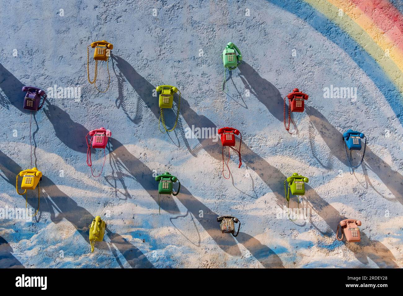 Una fila di telefoni colorati appende su un muro fuori da un edificio in Marocco Foto Stock