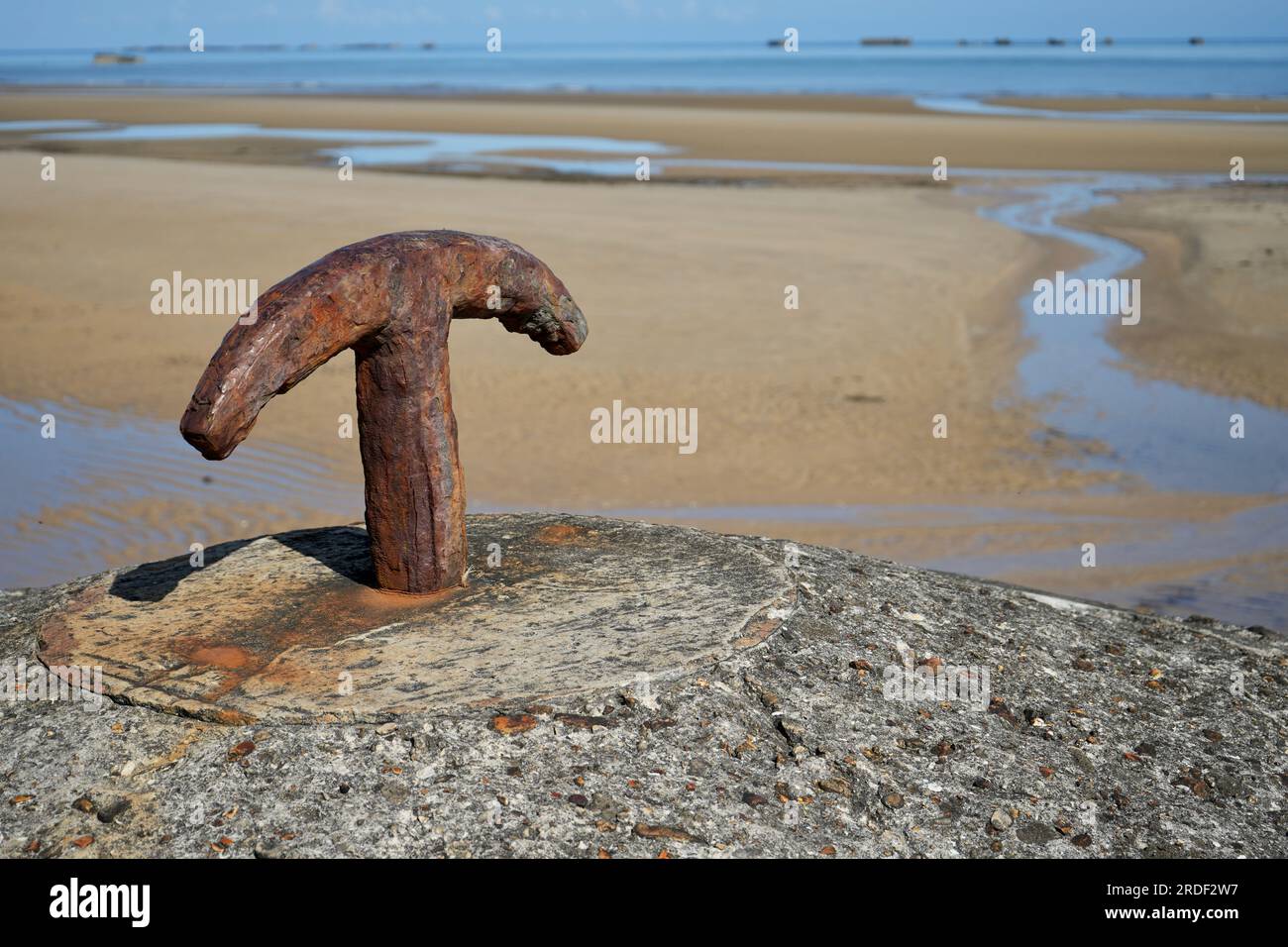 Rusty Iron Hook su un pilastro di cemento su una spiaggia in Normandia, Francia. Foto Stock