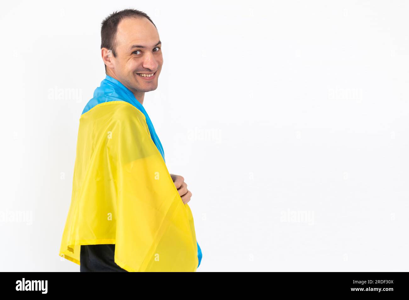 Giovane che detiene la bandiera Ucraina su sfondo bianco. Foto Stock
