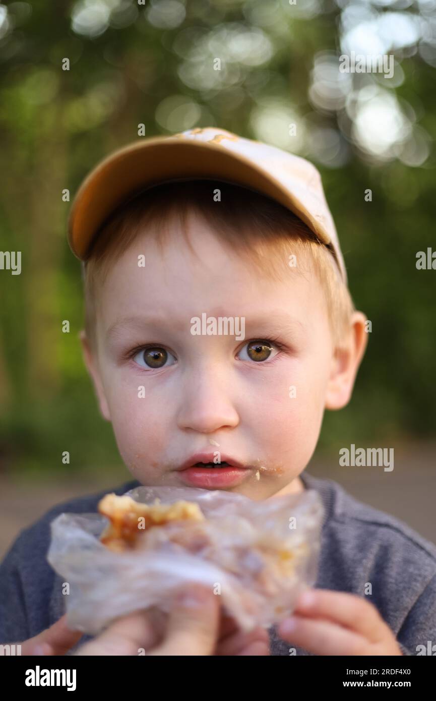 Ritratto di un ragazzo che mangia panino Foto Stock