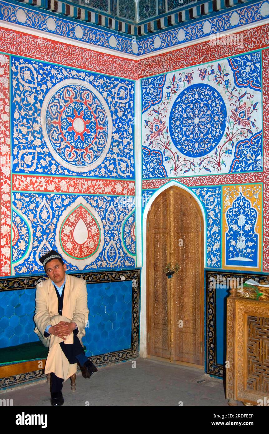 Uomo sulla panchina, Shahi Sinda, Kusam Ibn, di fronte al murale, Mausoleo Kussam-ibn-Abbas, necropoli di Shah-e-Sende, Samarcanda, Uzbekistan Foto Stock