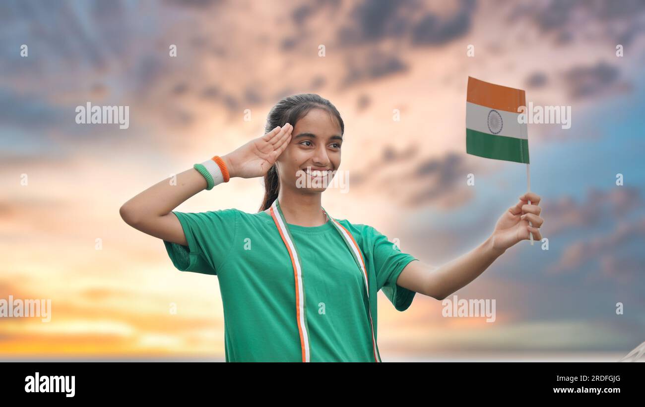 Ragazza adolescente che saluta e tiene in mano la bandiera indiana nell'umore patriottico in occasione delle celebrazioni in studio del giorno dell'indipendenza in India Foto Stock