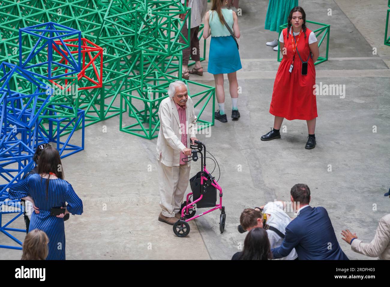 Londra Regno Unito. 21 luglio 2023 Zero to Infinity, grande scultura interattiva dell'artista britannico-pakistano Rasheed Araeen (nella foto) nella sala delle turbine a Tate Modern. si compone di 400 cubi a reticolo in una griglia 20x20 dipinte di blu giallo verde e rosso e disposte in una piazza sul pavimento della galleria. I visitatori sono invitati a rompere la sua disposizione simmetrica spostando e riconfigurando la struttura. La mostra si svolgerà dal 22 luglio al 28 agosto. Credit amer ghazzal/Alamy Live News Foto Stock