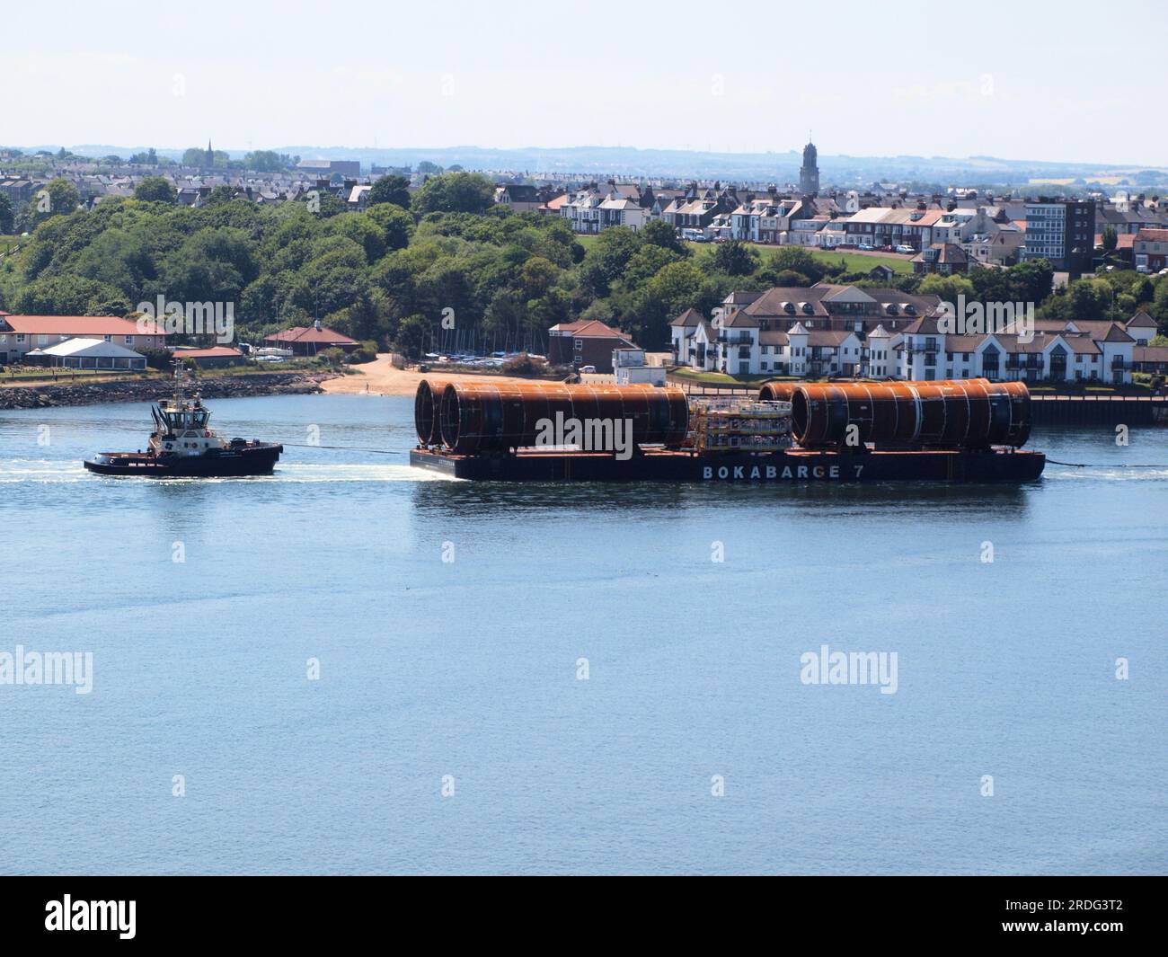 Turbine eoliche sottomarine in acciaio offshore piattaforme di fondazione per la produzione di energia eolica sono state trainate nel fiume Tyne per l'assemblaggio presso il cantiere Smulders. Foto Stock
