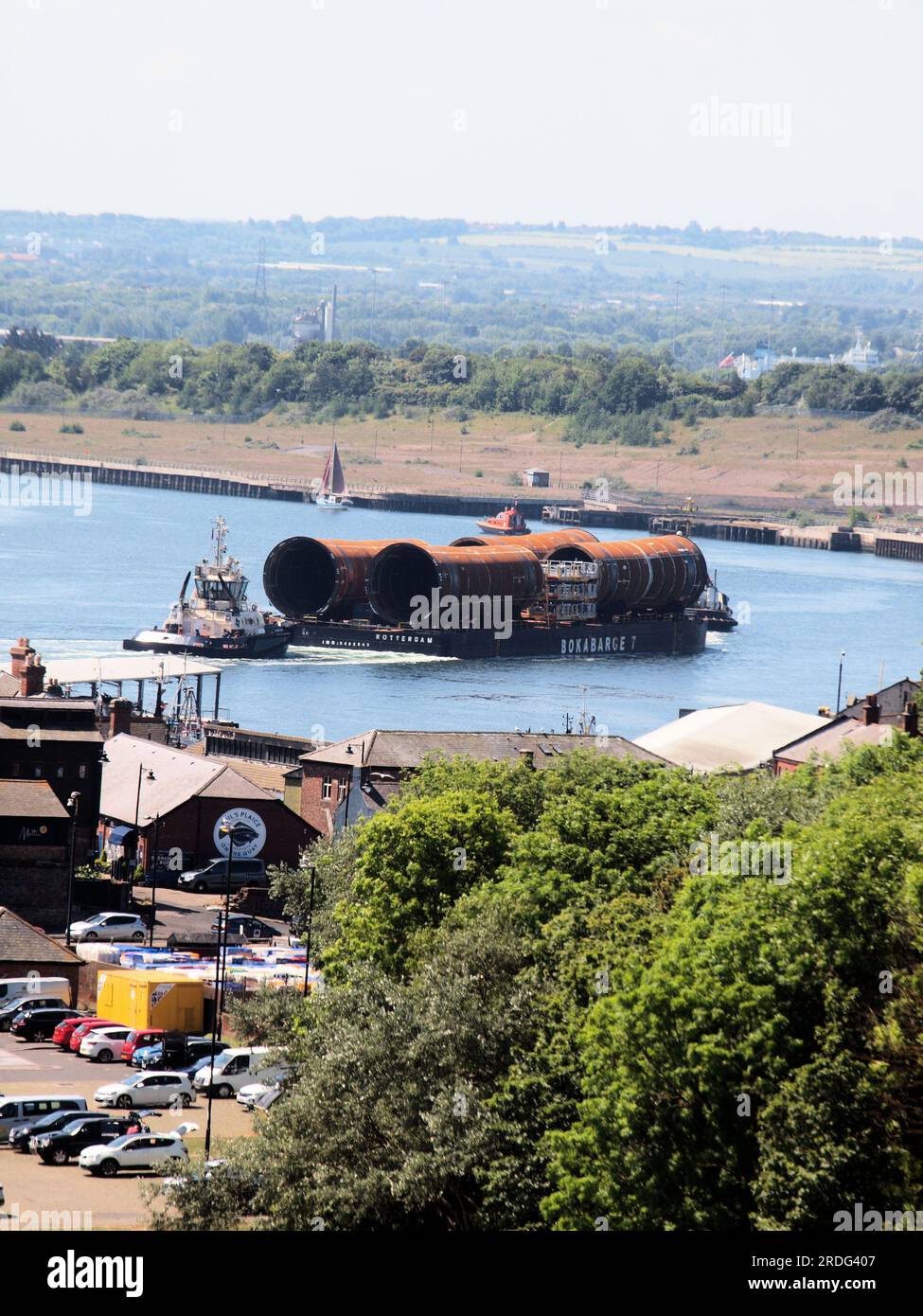Turbine eoliche sottomarine in acciaio offshore piattaforme di fondazione per la produzione di energia eolica sono state trainate nel fiume Tyne per l'assemblaggio presso il cantiere Smulders. Foto Stock