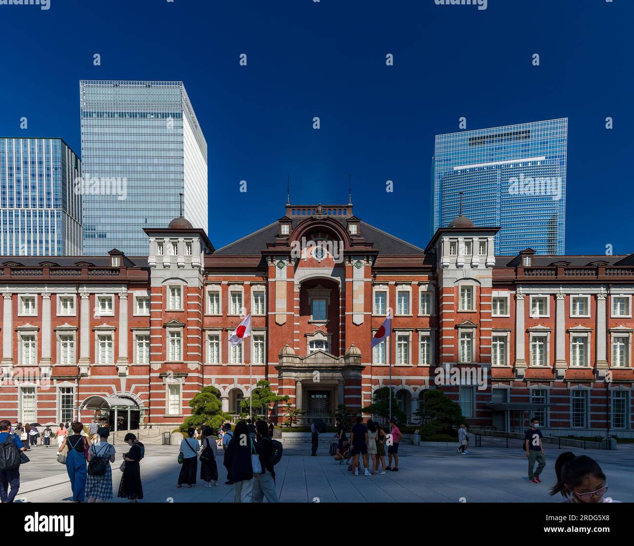 TOKYO, GIAPPONE - 16 LUGLIO 2023: Piccole folle di persone intorno all'edificio in mattoni rossi della stazione centrale di Tokyo in un caldo giorno estivo Foto Stock