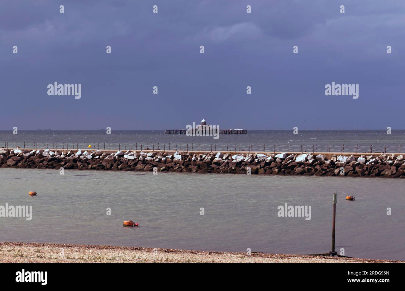 Vista dell'estremità del mare ora isolata di Here Bay Pier, attraverso il porticciolo formato da Neptune's Arm, Herne Bay, Thanet, Kent Foto Stock