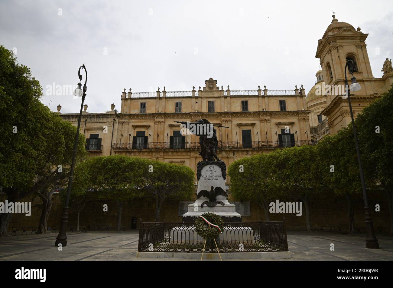 Vista panoramica del Palazzo Landolina in stile barocco-neoclassico e del monumento commemorativo ai caduti della prima guerra mondiale a noto in Sicilia, Italia. Foto Stock