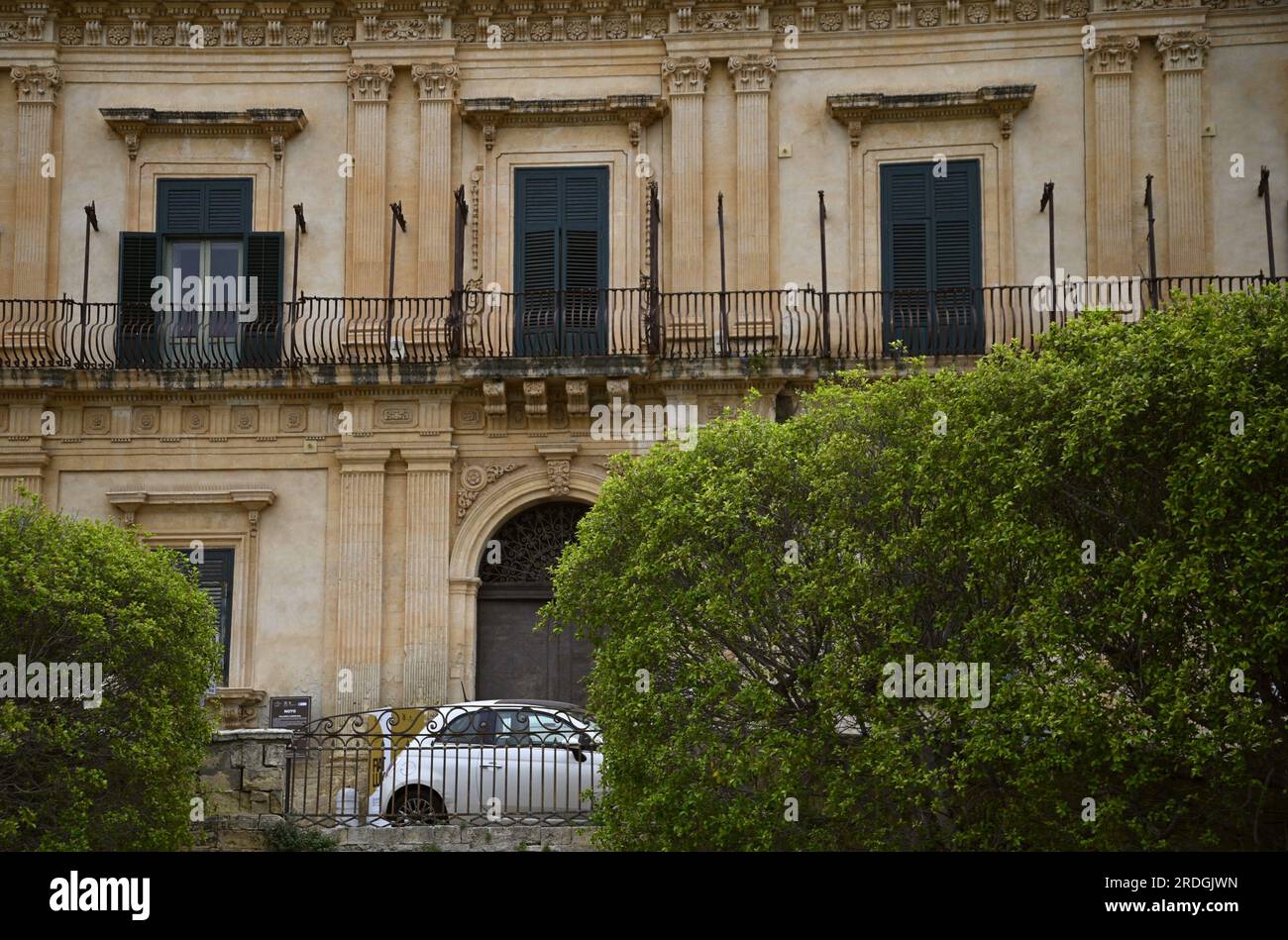 Fiat 500 d'epoca parcheggiata davanti al Palazzo Landolina in stile barocco-neoclassico a noto, in Sicilia. Foto Stock