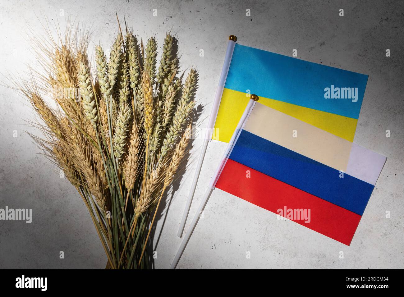 Orecchie di grano e due bandiere sul tavolo, un concetto sul tema della conclusione o della cancellazione di un accordo sul grano tra Ucraina e Russia Foto Stock