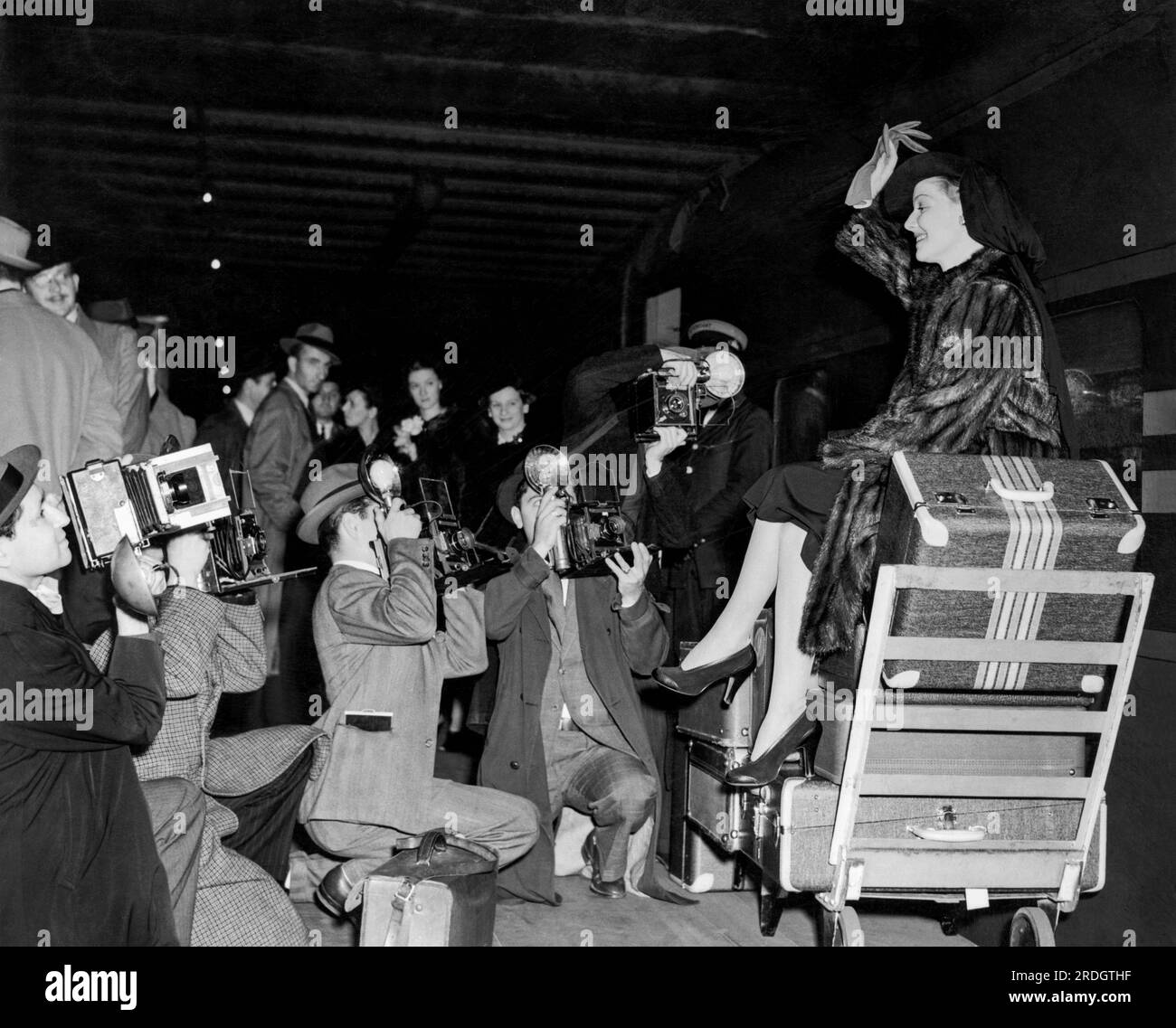 New York, New York: c. 1936 l'attrice Ann Sheridan viene accolta dai fotografi della stampa mentre arriva alla Grand Central Station in treno da Hollywood. Foto Stock