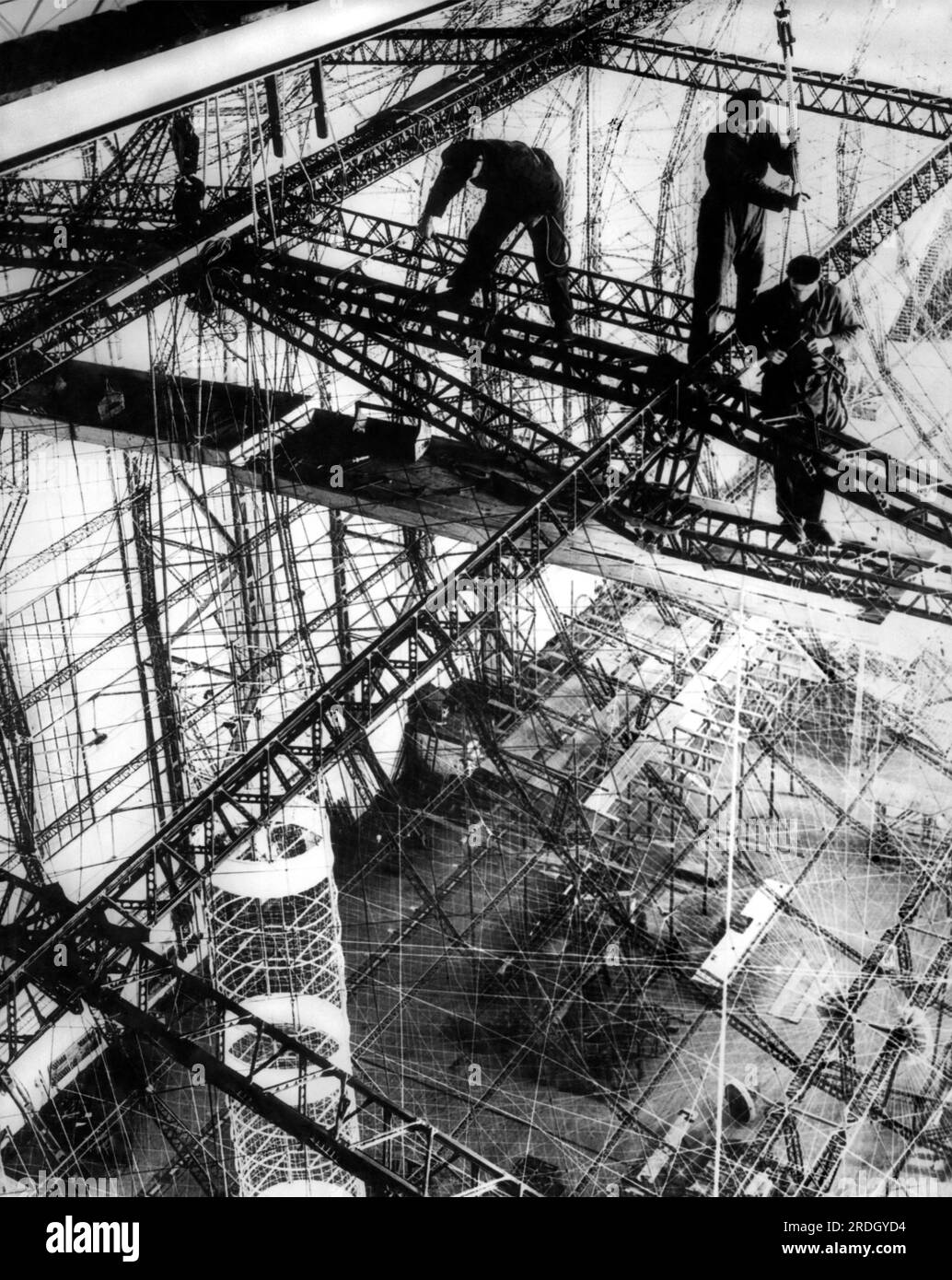 Friedrichshafen, Germania: c. 1933. Il telaio della LZ 129 sta prendendo forma presso gli stabilimenti Zeppelin di Friedrichshafen. Il suo nome deriva dal defunto Paul von Hindenburg, il presidente della Germania, morto nel 1934. Il telaio era fatto di Duralumin, una delle prime leghe di alluminio, e la pelle doveva essere di cotone che era drogato con una miscela di alluminio e ossido di ferro per proteggerlo dalla luce ultravioletta e infrarossa. Purtroppo, questa miscela ha reagito violentemente quando è stata riscaldata, con conseguenti temperature estremamente elevate. Foto Stock